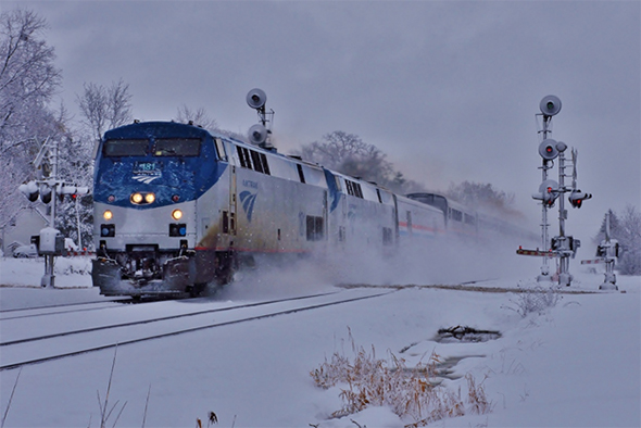 The FRA announced that Amtrak delivered its PTC operating plan to the agency last week; one of the last big pieces of the PTC planning puzzle. Here Amtrak’s Empire Builder flies west over the river and through the woods in Deerfield, Illinois during Thanksgiving week last year. Image © 11/2015 by Nikki Burgess; all rights reserved.