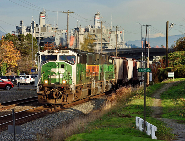 The Department of Homeland Security announced a regulatory review with public input that will address potential changes to how the agency handles dangerous goods and other safety issues, with a focus on both rail transport and port security as two of the main objectives. A BNSF freight train passes the Port of Tacoma, Washington on October 22nd, 2016. Image © 10/2016 by Nikki Burgess; all rights reserved.